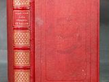 un livre rouge à reliure dorée et à couverture rouge