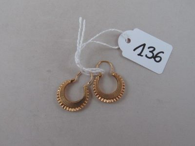 pair of gold hoop earrings with a price tag on a white background