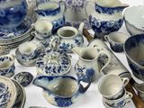many blue and white dishes and cups on the table