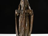 statue of a woman holding a cross on a white surface