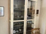 a white cabinet with glass doors in a room
