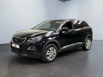 Une voiture noire est garée dans une pièce au sol noir.
