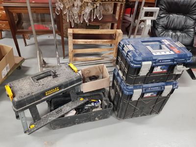 a pile of tools sitting on the floor next to a chair