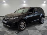 Une Land Rover noire est garée dans une pièce au sol carrelé en damier.