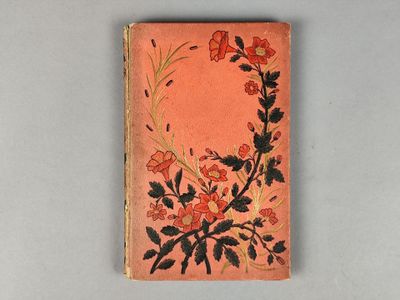 un vieux livre orné d'un motif floral, posé sur une table