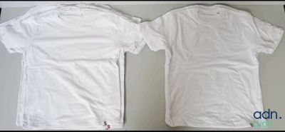 two white t - shirts sitting next to each other on top of a table