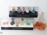cinq flacons de parfum différents dans une vitrine