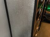 a silver refrigerator in the corner of a room next to a shelf