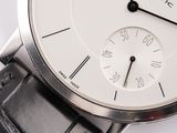 a close up of a wrist watch with a white dial