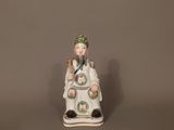 figurine en porcelaine représentant une femme assise sur un tabouret, tenant un oiseau dans la main