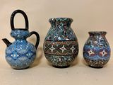 trois vases sont posés les uns à côté des autres sur une table