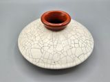 a white and red vase with cracky paint on it