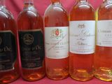 six bottles of wine sitting next to each other on a pink background