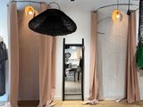 une photo d'une pièce où se trouvent de nombreux vêtements suspendus à des cintres
