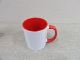 a red and white mug sitting on a table