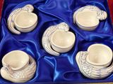 four cups and a saucer in a blue box