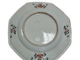 a white plate with red flowers on it on a white background