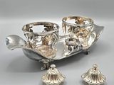 an image of a silver plate with two cups and a spoon