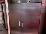 a stainless steel refrigerator in a kitchen with tile flooring
