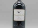 une bouteille de vin rouge posée sur une table blanche