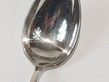 a spoon that is sitting on a white surface
