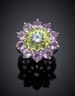 a close up of a purple and green flower ring on a black surface