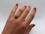 woman ' s hand with red manicured nails and a gold ring