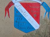 painting of a coat of arms on a wall with a blue ribbon and a red and white ribbon