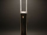 a black table lamp on a wooden table with a black background