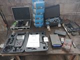 une table sur laquelle se trouvent un ordinateur portable, un écran et d'autres appareils électroniques