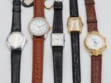 several different types of watches are lined up on a white surface