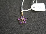 un gros plan d'un collier orné d'une fleur violette
