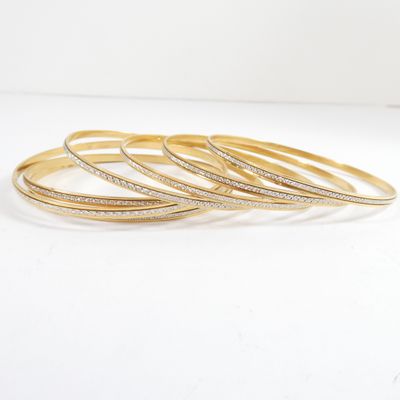 a set of five gold bangies with diamonds on them