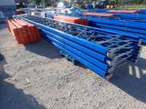 un tas de tuyaux en acier bleus et orange dans un parking