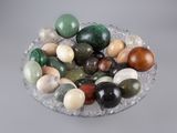 un bol en verre rempli de nombreuses pierres de différentes couleurs