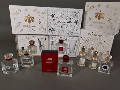 several bottles of perfume are sitting on a table in front of a box