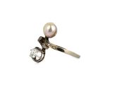 a close up of a pearl and diamond ring on a white background