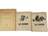 three books sitting on top of each other on a white surface