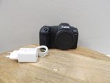 a camera sitting on a wooden table with a charger