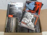 une boîte remplie de CD et des CD posés sur une table