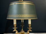 an antique brass table lamp with a green shade