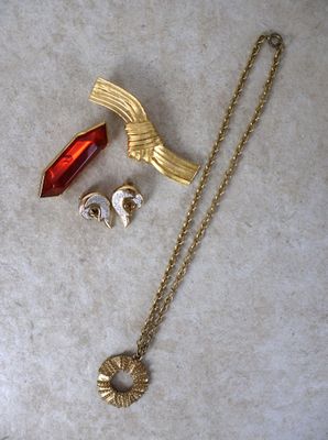 un collier, des boucles d'oreilles et une broche posés sur une table