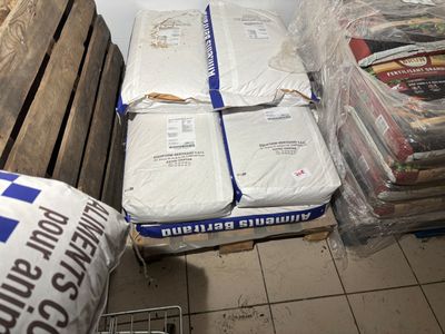 a pile of mattresses sitting on the floor next to a pile of bags