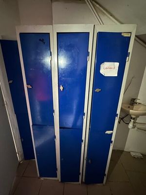 three blue lockers in a bathroom next to a toilet