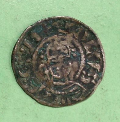 an old coin sitting on top of a green surface