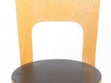 a wooden chair with a black seat on a white background