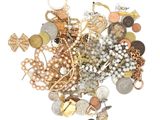 a pile of gold and silver jewelry on a white surface
