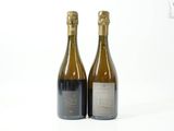 deux bouteilles de vin posées l'une à côté de l'autre sur une surface blanche
