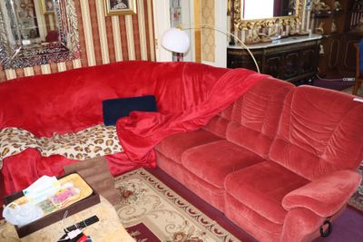 un canapé rouge dans un salon avec un miroir accroché au mur