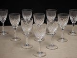 six wine glasses sitting on a table with a black background